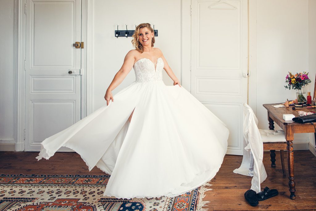 la mariée fait valser sa robe dans la chambre du domaine pendant les préparatifs