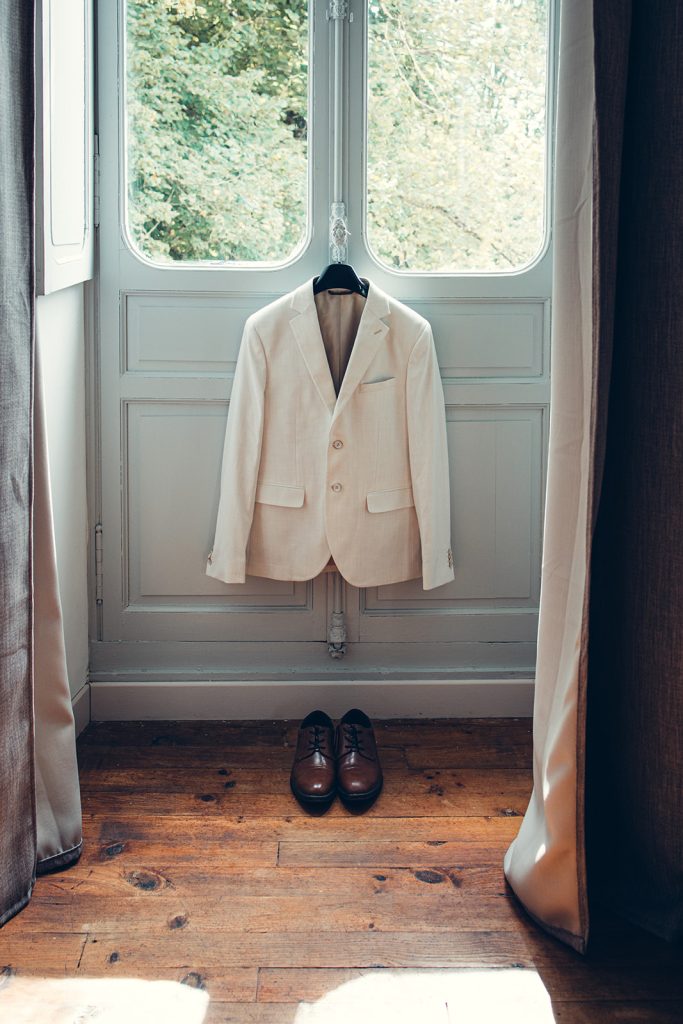 costume suspendu du marié dans la chambre du domaine sous une belle lumière