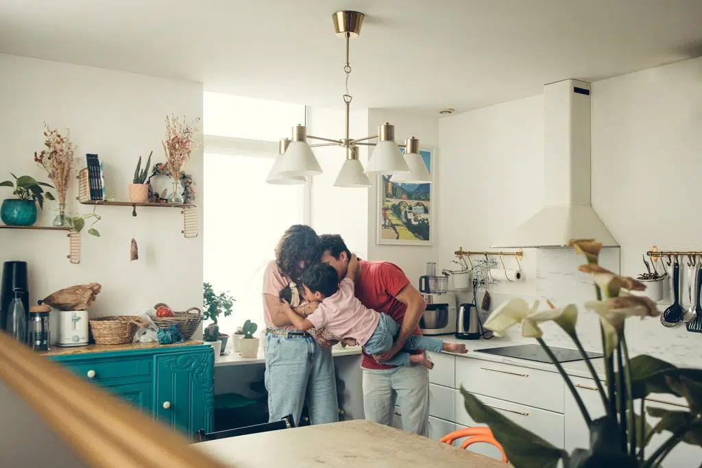 Famille qui s'embrasse dans le reflet du miroir lors d'une séance naissance à domicile à nay