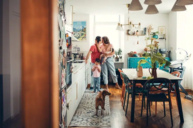 Famille unit et aimante dans leur magnifique cuisine très bien décorée lors d'une séance naissance à domicile à nay