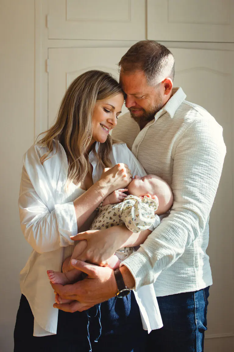 portrait des parents avec leur bébé dans la lumière lors d'une séance photo famille à domicile à Soumoulou