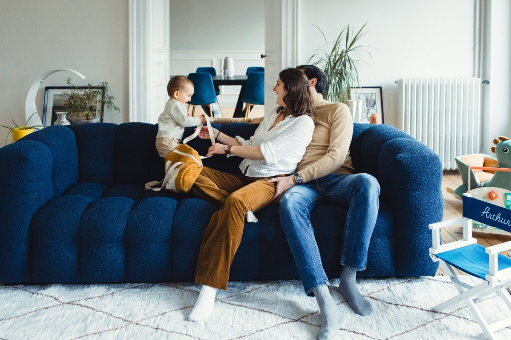une famille joue sur le canapé avec leur enfant séance famille domicile pau