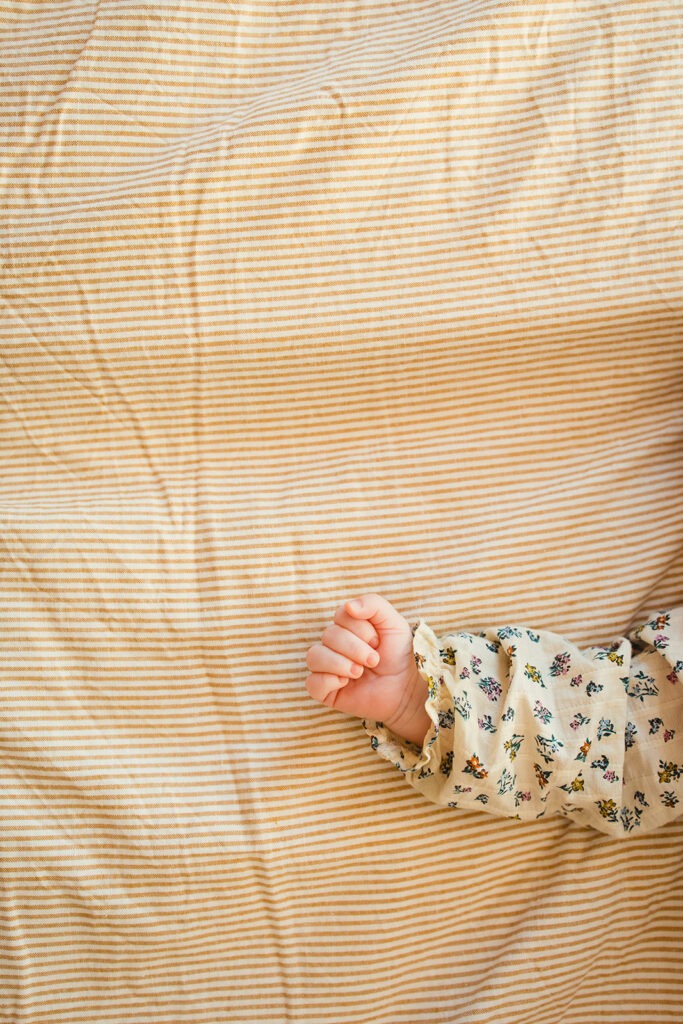 petite main de bébé sur le lit