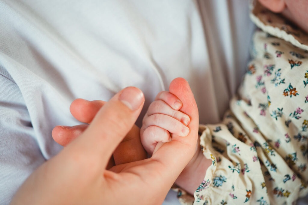 le grand frère tient la main de sa petite soeur séance naissance domicile soumoulou