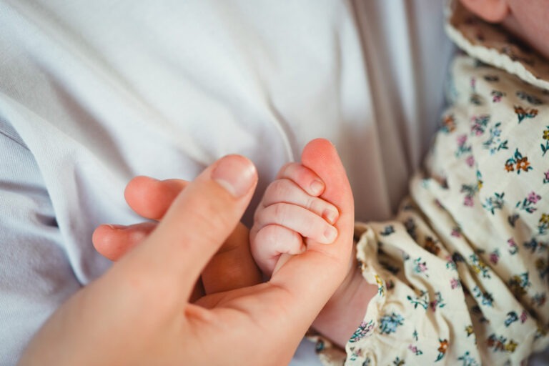 le grand frère tient la main de sa petite soeur séance naissance domicile soumoulou